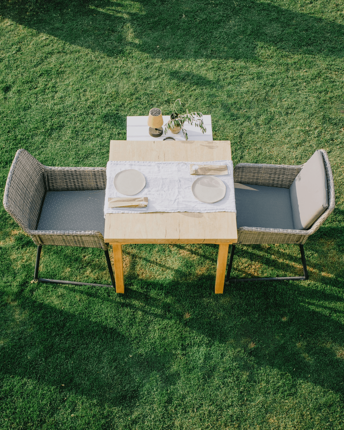 Overhead view of a table set for two on the grass